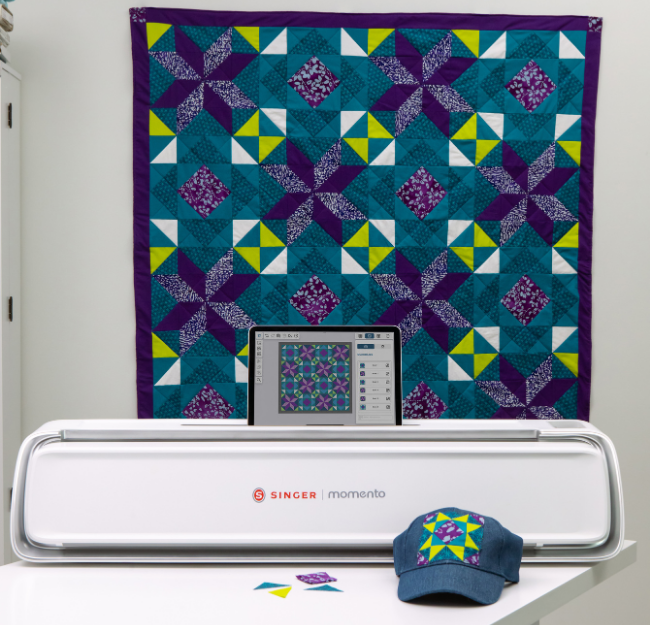  Máquina momento, em cima de uma mesa, com tapete de patchwork atrás 